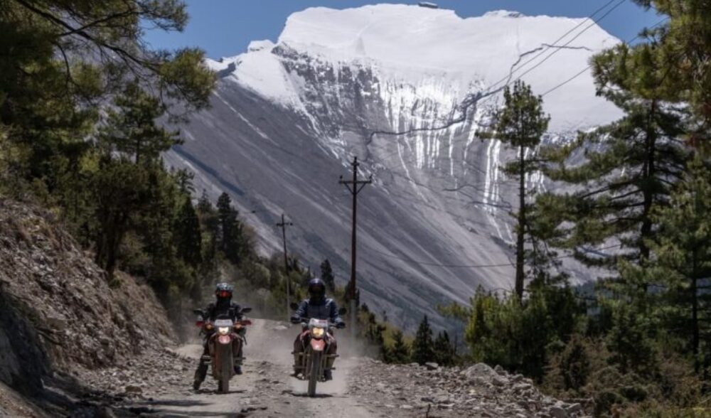 Two riders traveling on Honda dual-sport motorcycles along scenic mountain roads.
