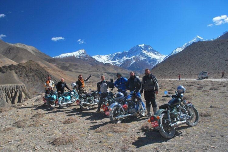Riders proudly posing with the Himalayas in Mustang motorcycle tour
