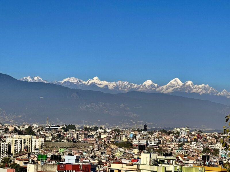Himalayas from Patan during 5 days Everest gateway to Chitwan Park motorcycle tour. Scenic snow-capped mountain panorama along the Nepal riding route.