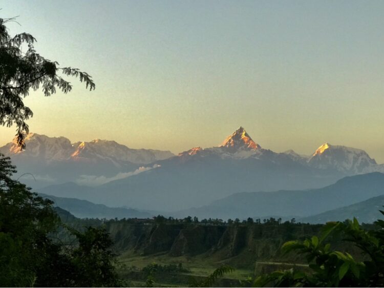 Stunning sunset over the Annapurna Himalayas on a scenic golden pyramid view Nepal ride motorcycle tour.