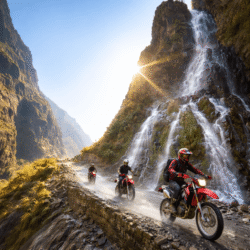 Scenic Manang waterfall rushing past the rugged off-road track between Besisahar and Chame during a Himalayan motorcycle tour in Nepal.